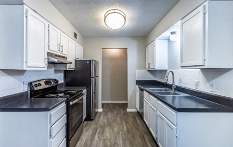 A kitchen with black countertops and white cabinets.