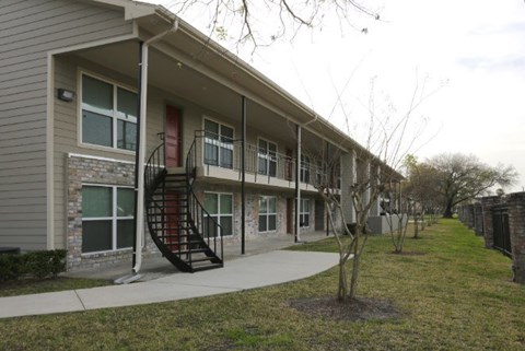 A building with a red door and a black spiral staircase.