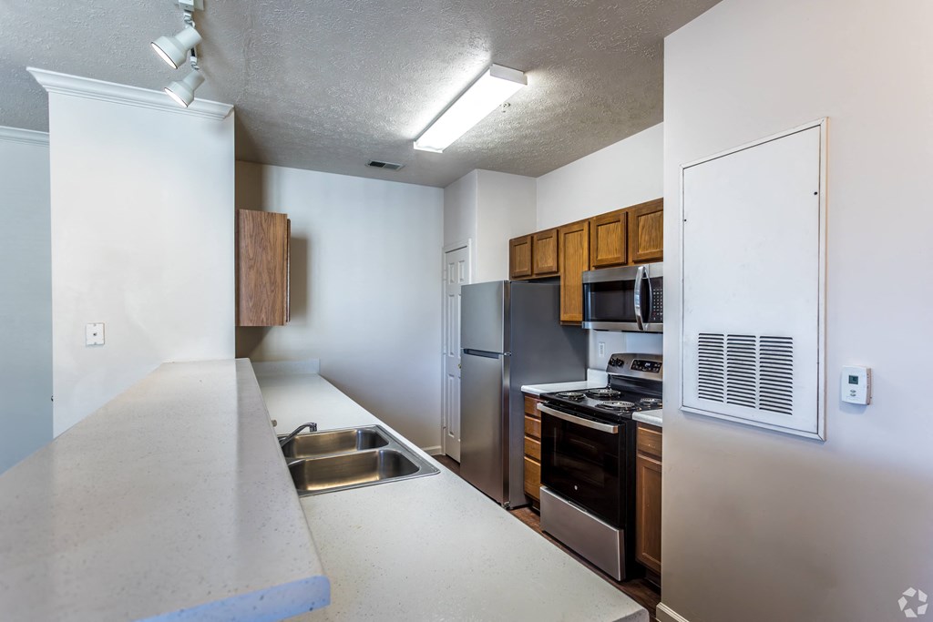 A kitchen with stainless steel appliances and wooden cabinets.