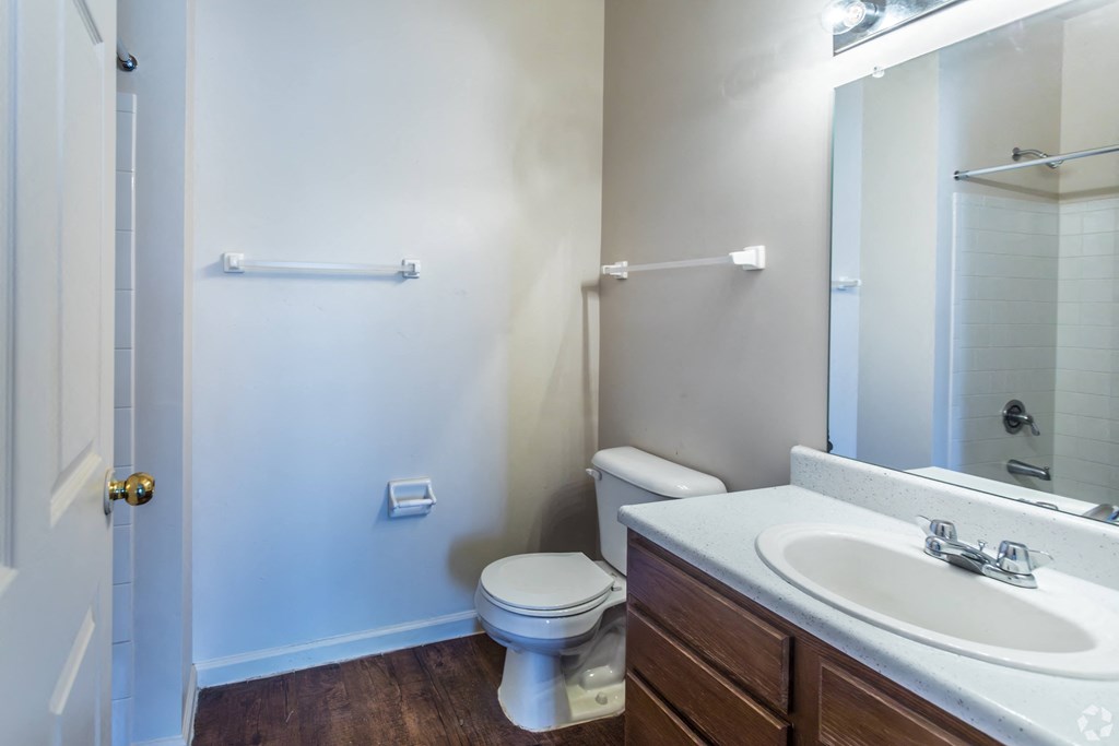 A white toilet sits in a small bathroom next to a sink.