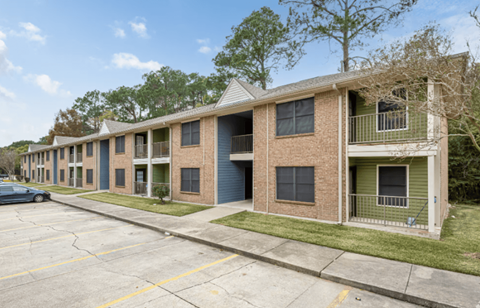 A row of apartment buildings with a car parked in front.
