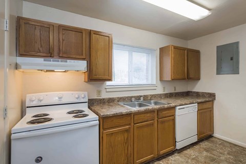 A kitchen with a white stove and wooden cabinets.