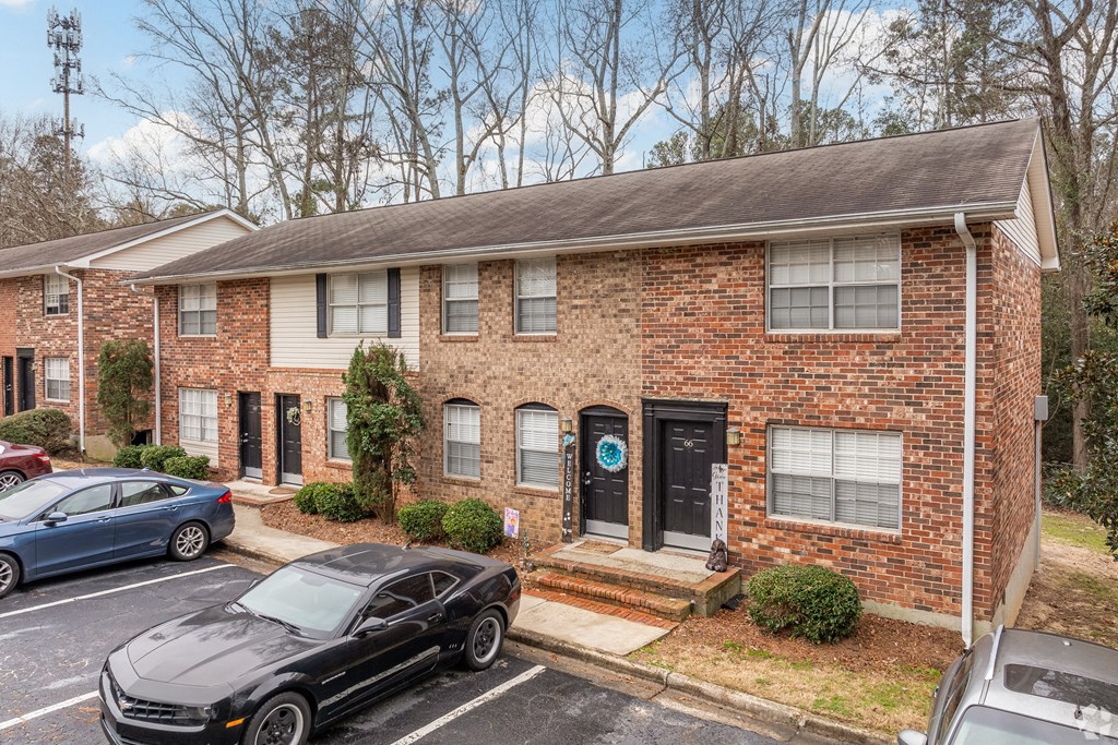 a brick house with cars parked in front of it