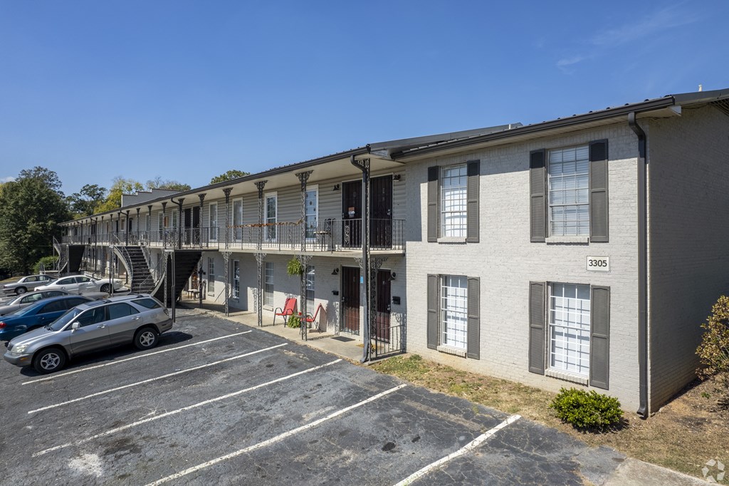 an apartment building with cars parked in a parking lot