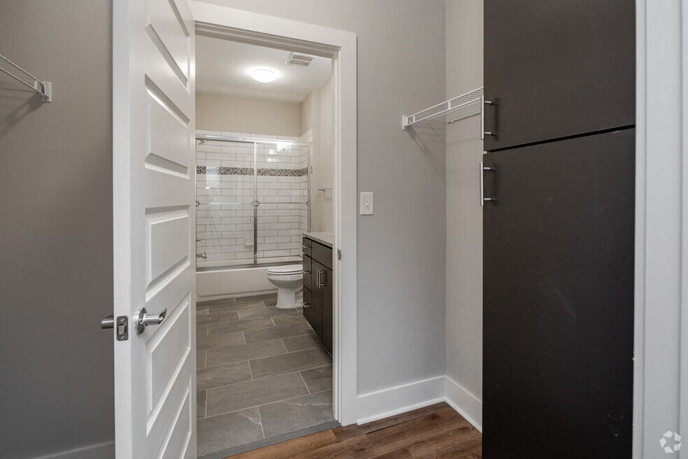 a door opens into a bathroom with a shower and a toilet