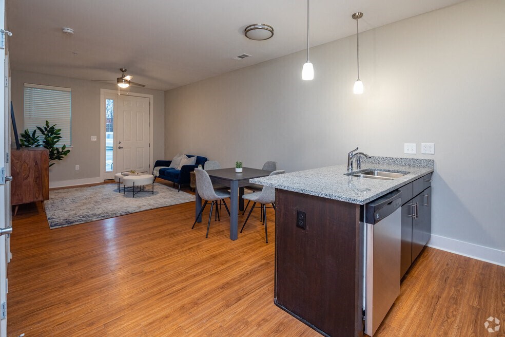 an empty living room with an open kitchen and dining area