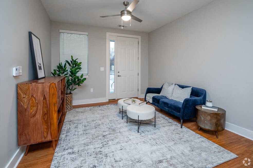 a living room with a blue couch and a ceiling fan