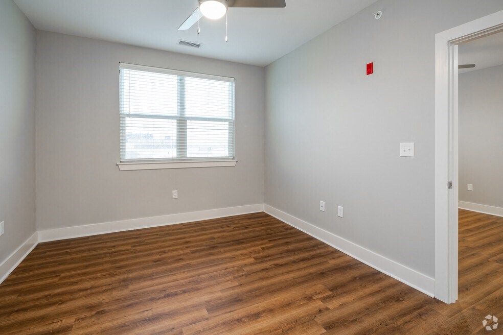 an empty living room with wood floors and a window