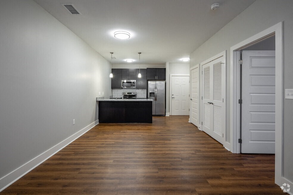 a kitchen and living room with wood floors and white closets
