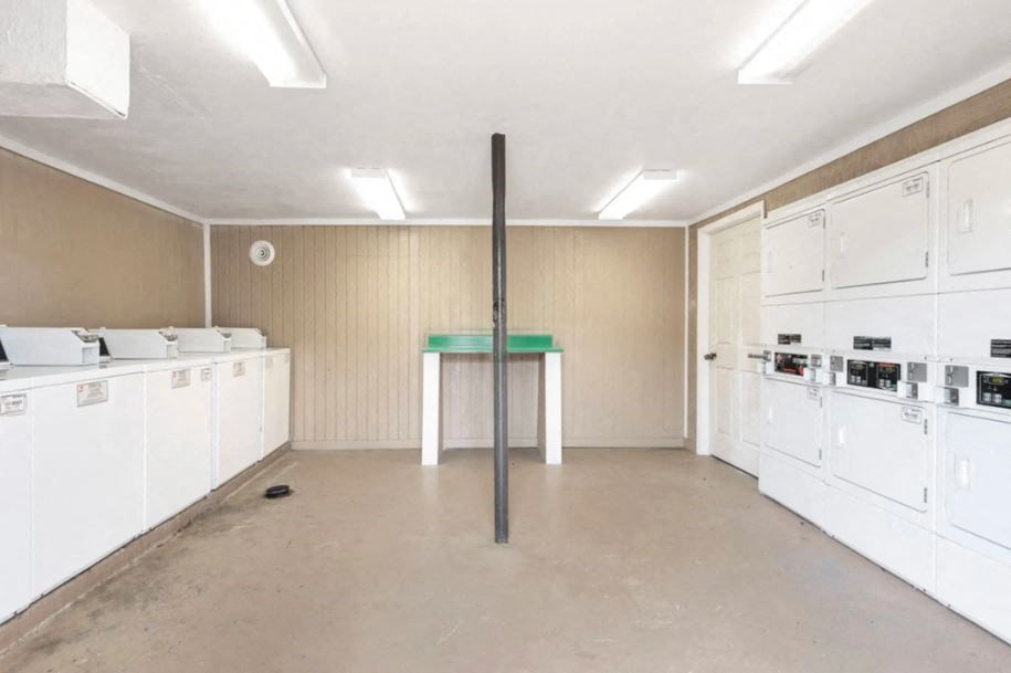 an empty kitchen with white appliances and a green table