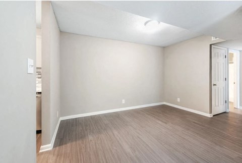 an empty living room with white walls and wood flooring