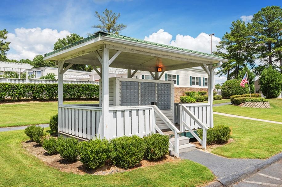 a white gazebo with a porch in a yard