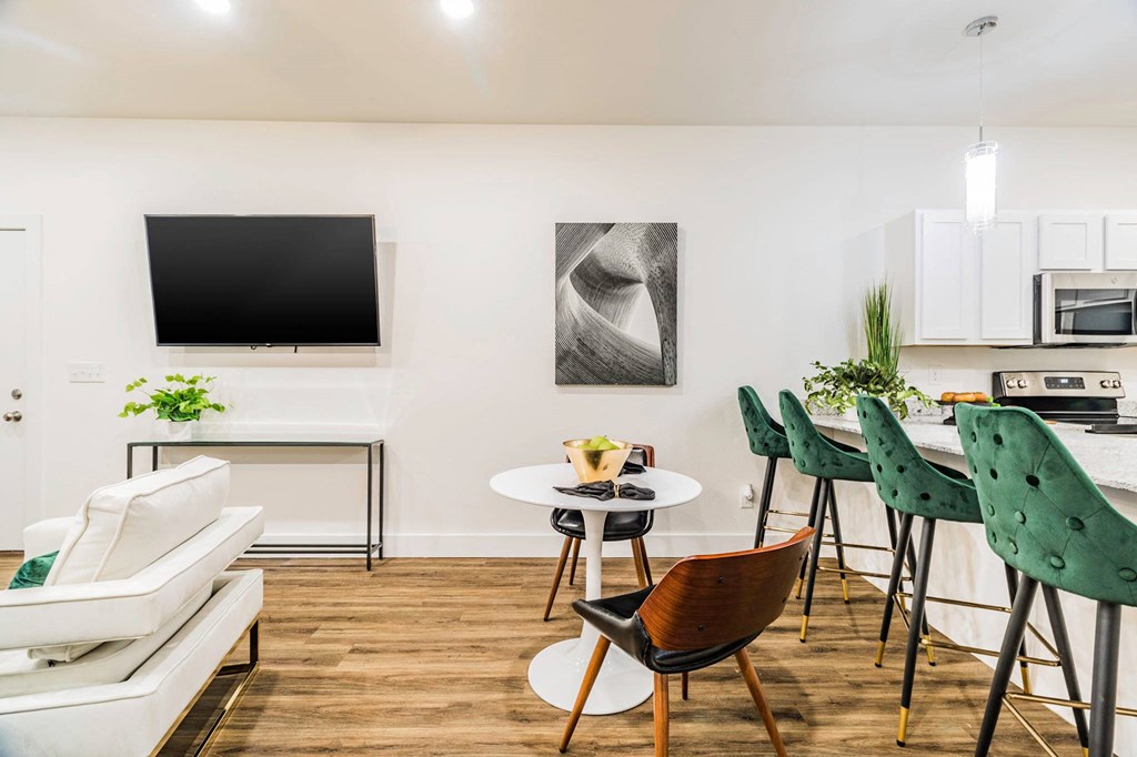 a living room with a white couch and a tv on the wall