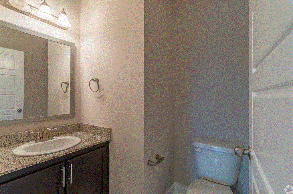 a bathroom with a toilet sink and mirror