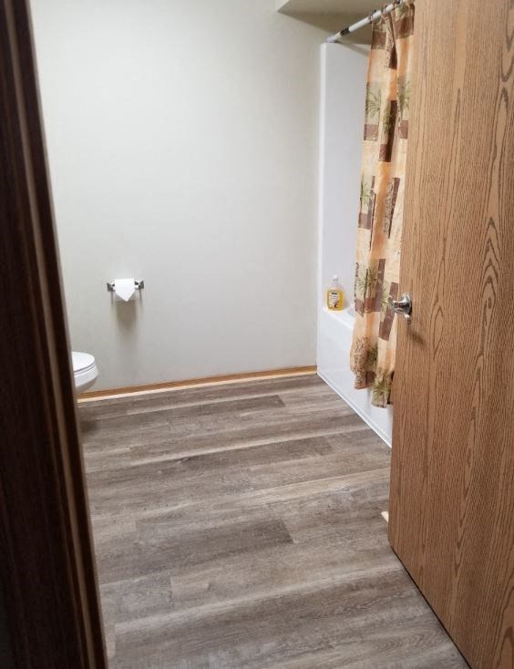 a bathroom with a toilet and a shower curtain