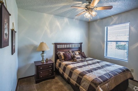 a bedroom with a bed and a ceiling fan