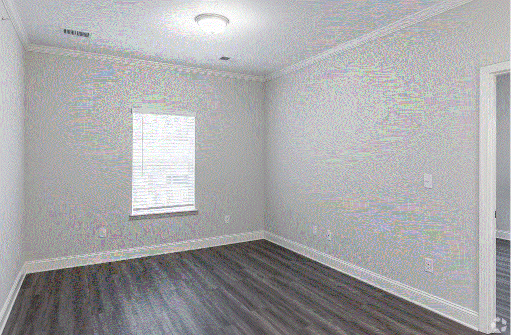 an empty bedroom with gray walls and white trim