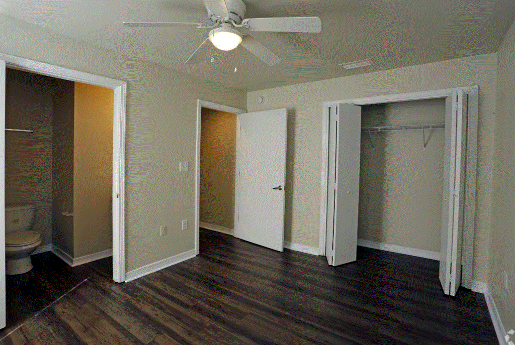 an empty bedroom with a ceiling fan