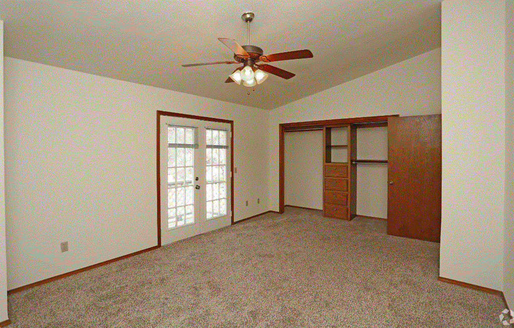 a bedroom with a ceiling fan and a closet