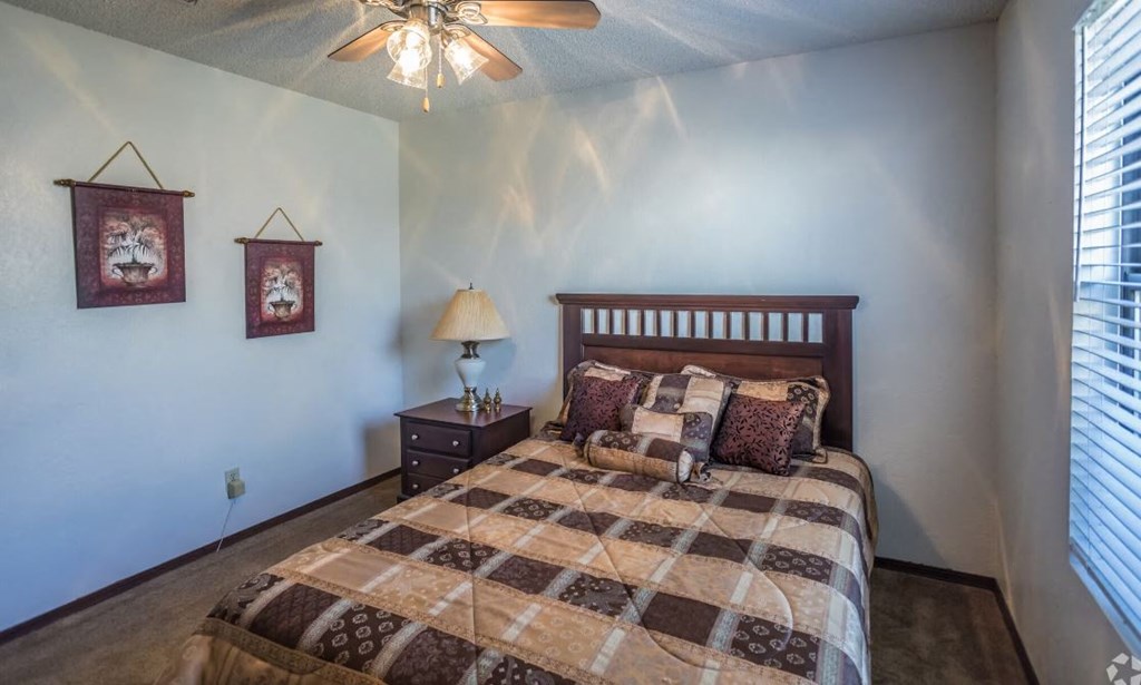 a bedroom with a bed and a ceiling fan