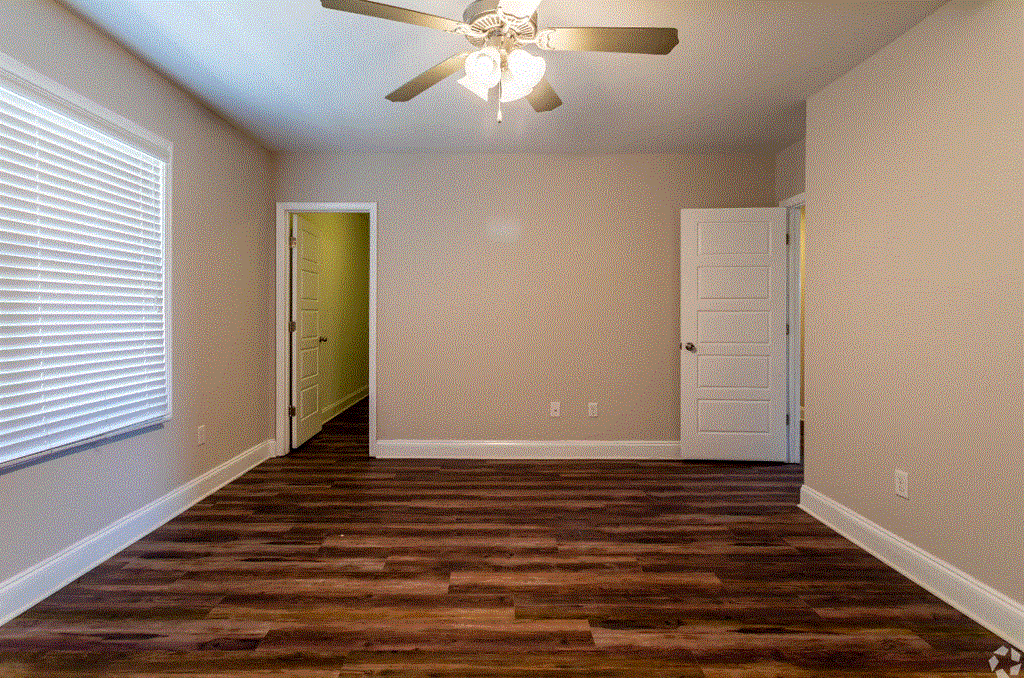 a bedroom with hardwood floors and a ceiling fan