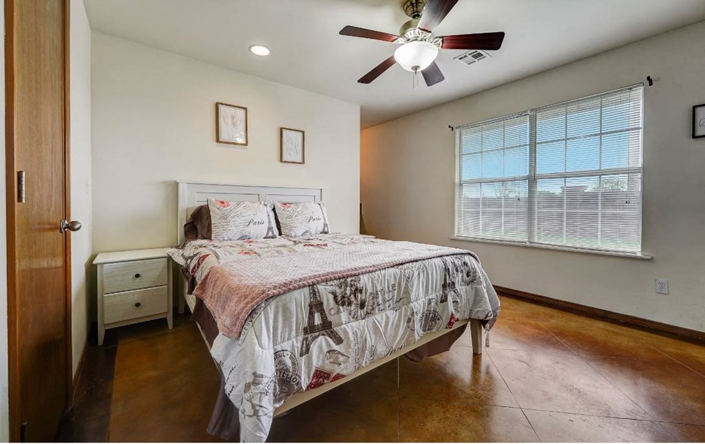 a bedroom with a bed and a ceiling fan