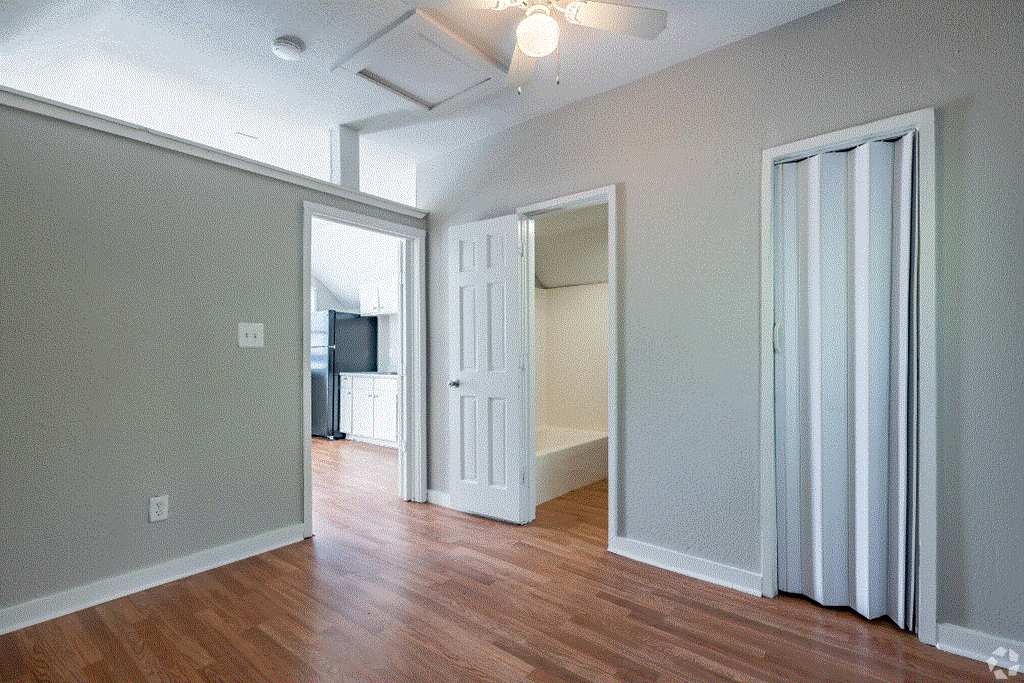 an empty living room with a ceiling fan