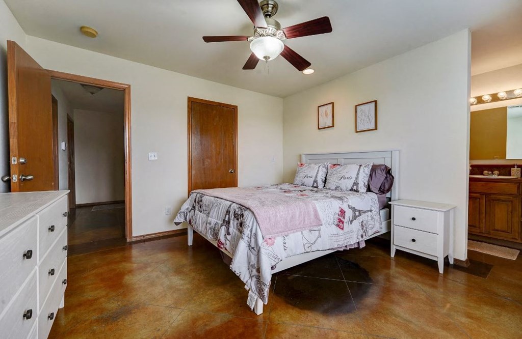 a bedroom with a bed and a ceiling fan