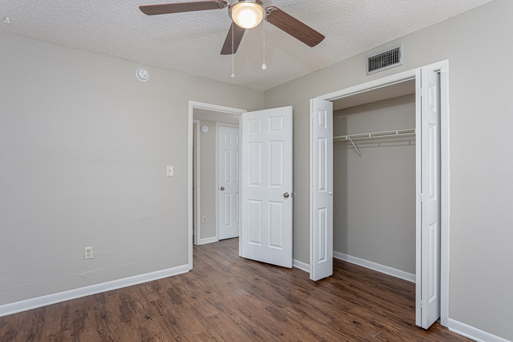 a bedroom with a ceiling fan and closet