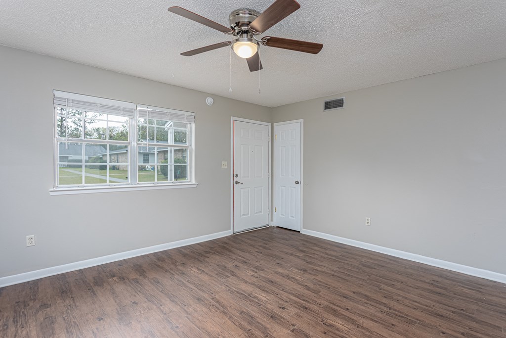 an empty bedroom with a ceiling fan