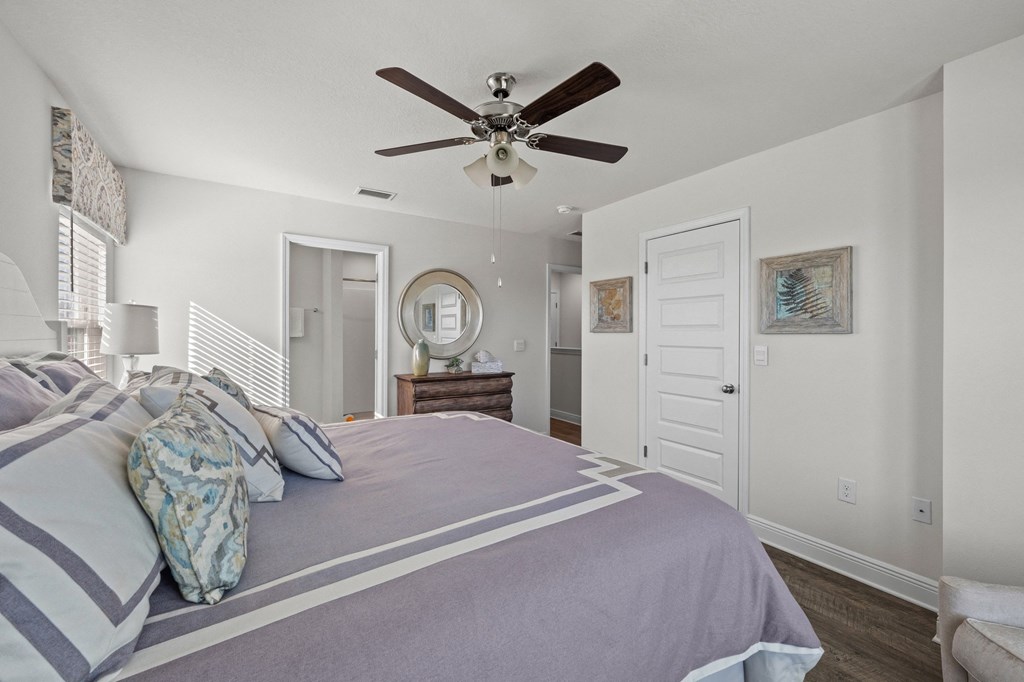 a bedroom with a large bed and a ceiling fan