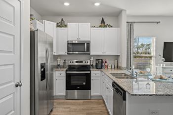 a kitchen with white cabinets and stainless steel appliances