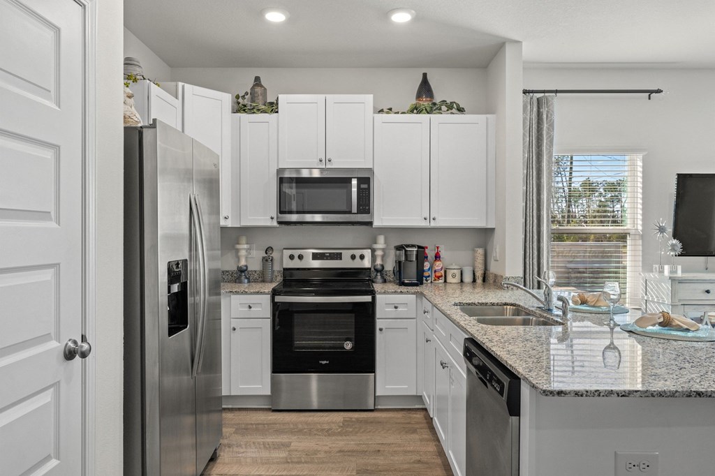 a kitchen with white cabinets and stainless steel appliances