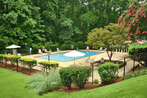 a backyard with a swimming pool and a wrought iron fence