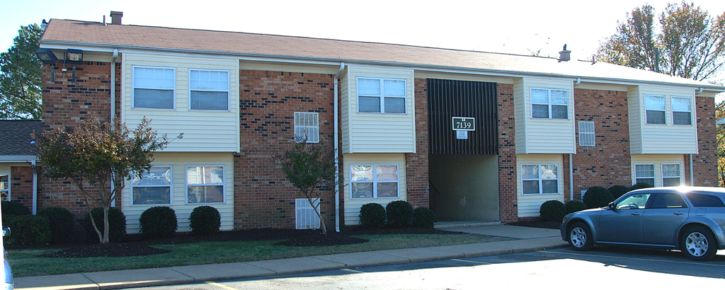 an apartment building with a car parked outside