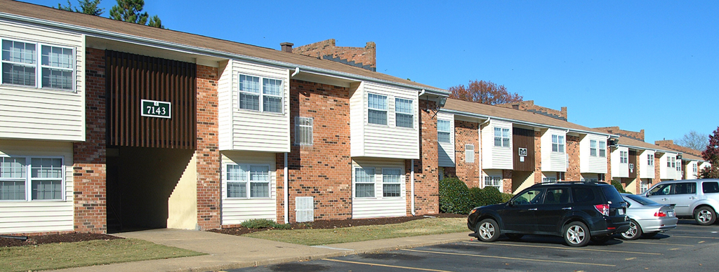 an apartment building with cars parked in front of it