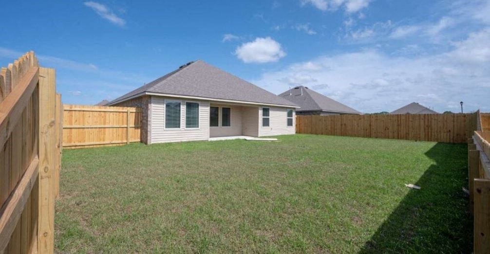 a backyard with a fence and a house