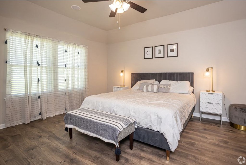a bedroom with a bed and a ceiling fan
