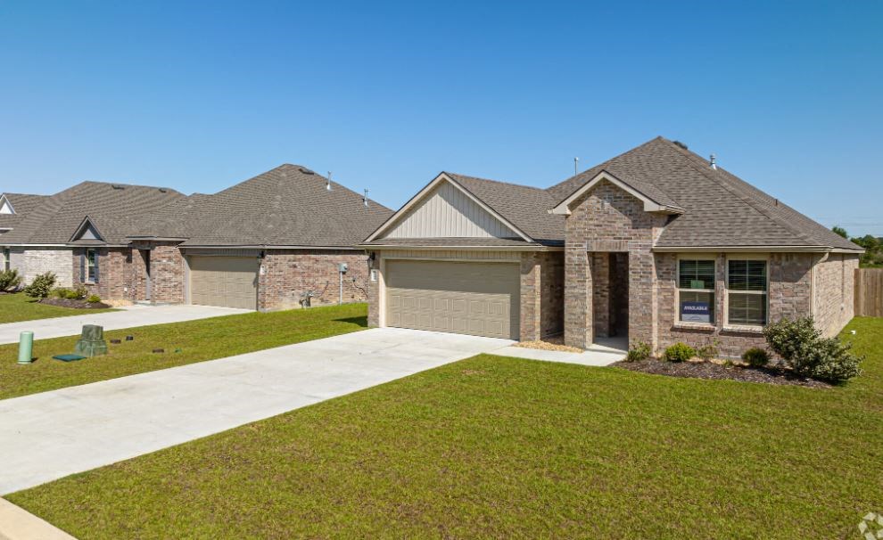 a house in a subdivision with a sidewalk and grass