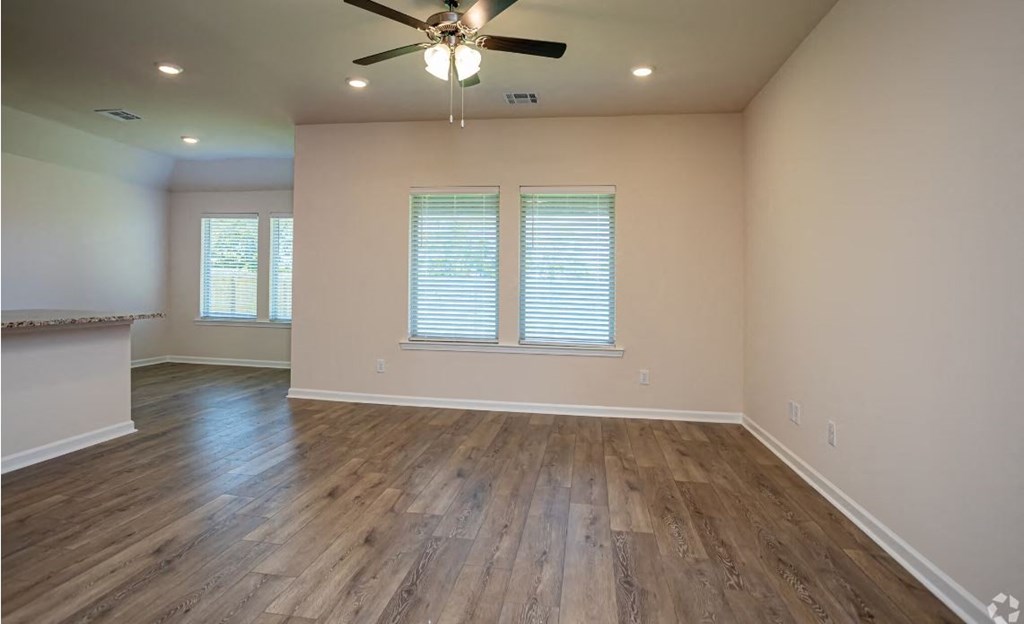 a living room with wood floors and a ceiling fan