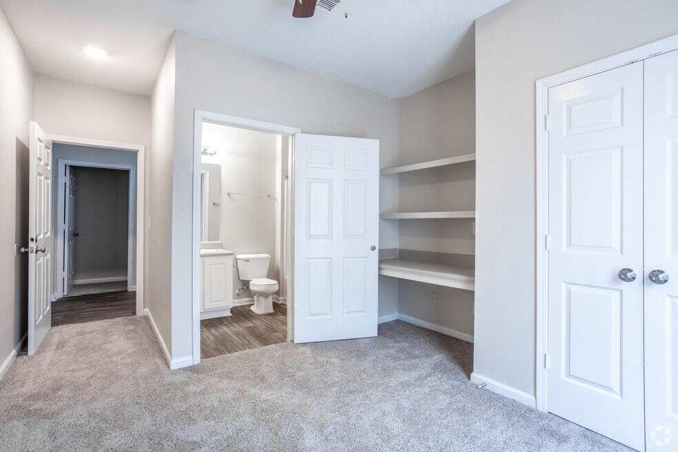 a bedroom with a closet and a bathroom with a toilet