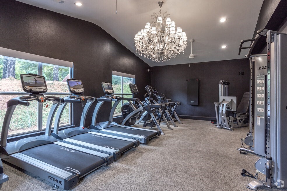 a gym with cardio machines and a chandelier
