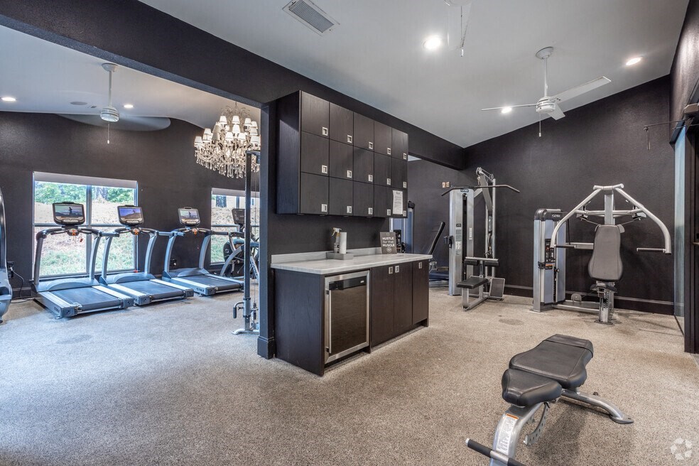 a gym with weights and a counter and a chandelier