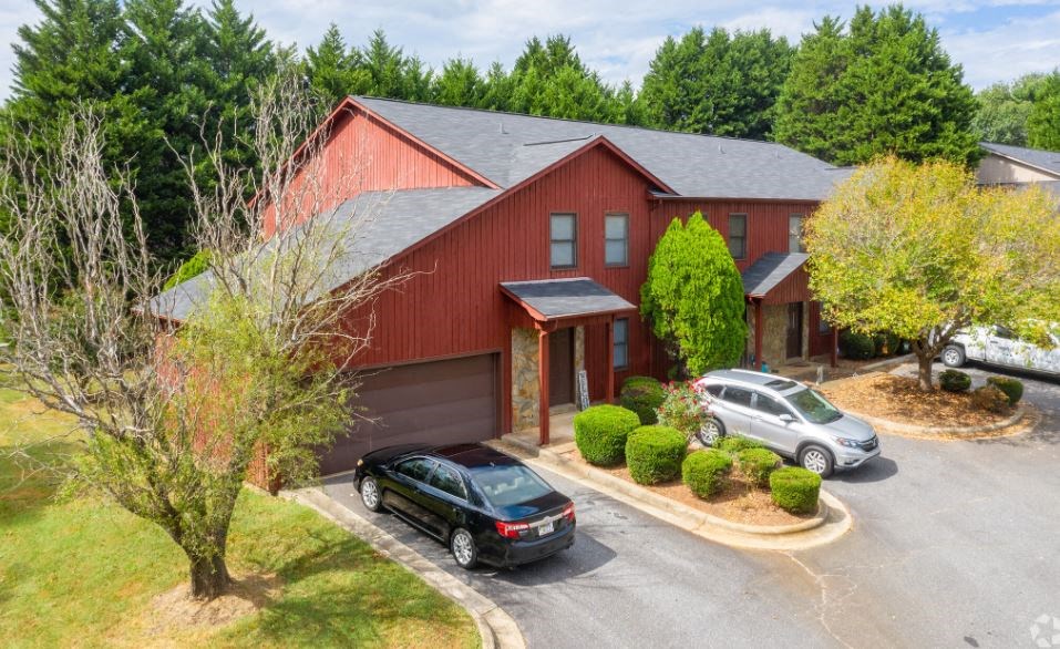 a red house with a black car parked in front of it