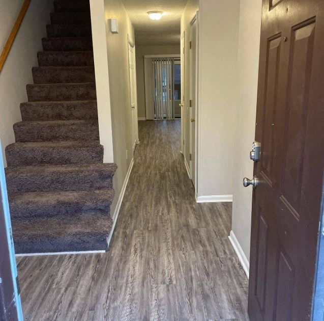 a hallway with a stairs and a door