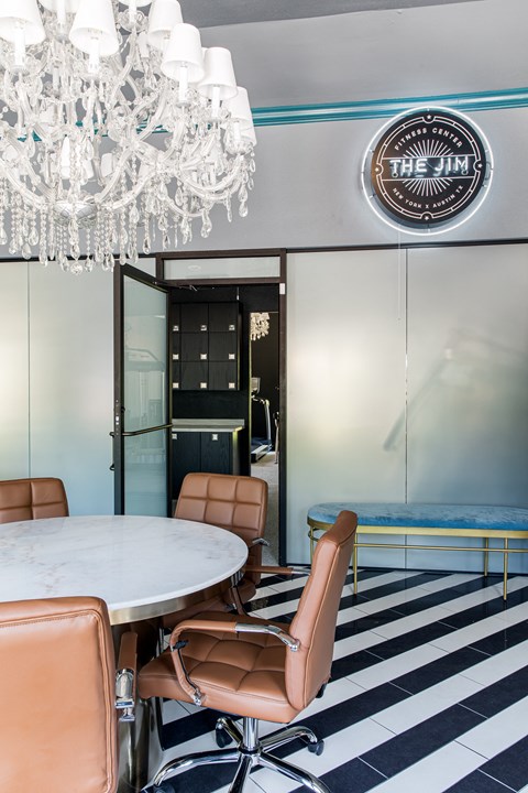 a dining room with a marble table and leather chairs