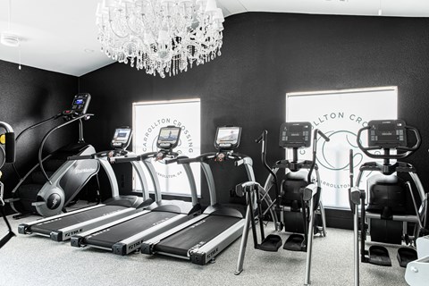 a row of treadmills in front of a chandelier in a gym