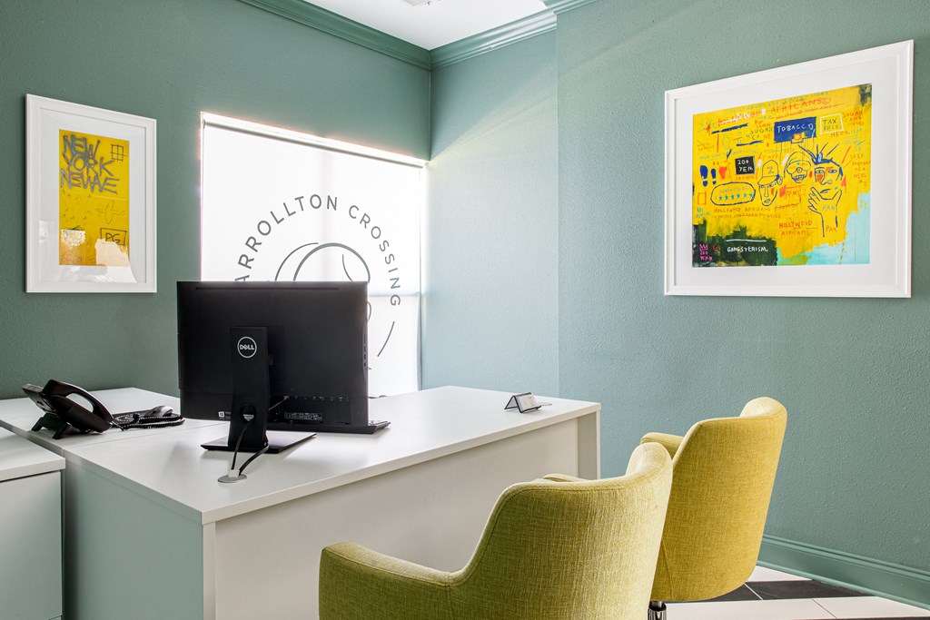 a desk with a computer monitor and three yellow chairs