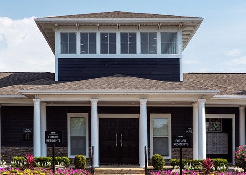 the front of a house with two black doors and two white columns