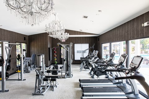a gym with cardio machines and chandeliers
